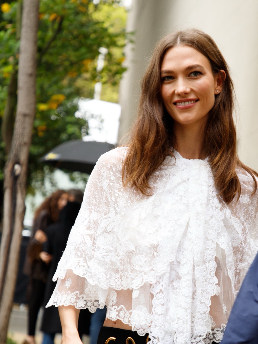 Karlie Kloss in a white lace cape outside the Chloé Spring/Summer 2025 show, Paris Fashion Week